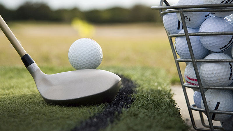 golfer taking a swing at the driving range